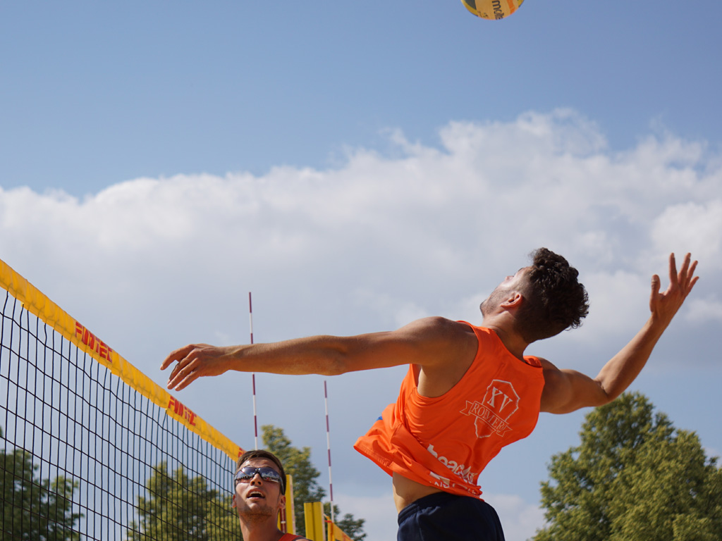 Ein Beachvolleyballer holt zum Schmetterball aus