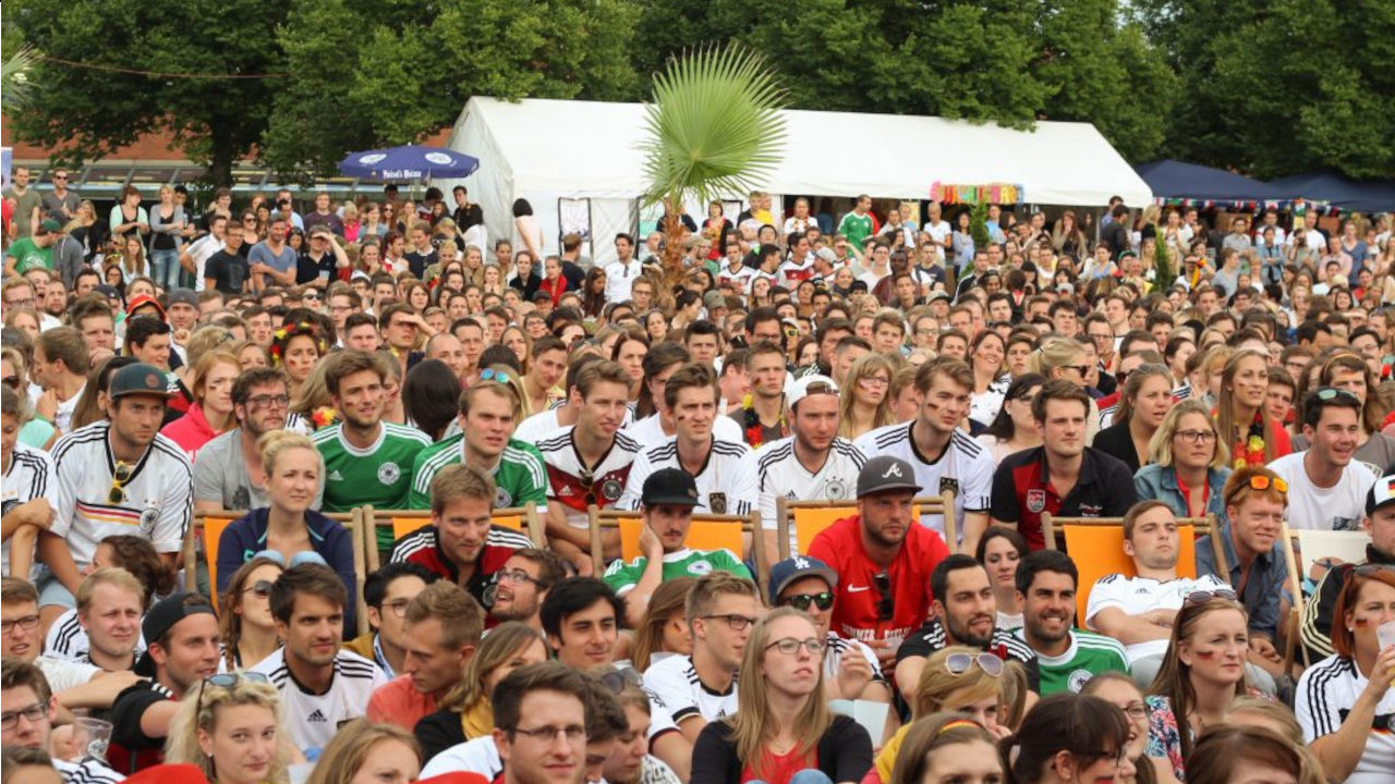 Zuschauer einer public viewing veranstaltung aus Sicht der Leinwand